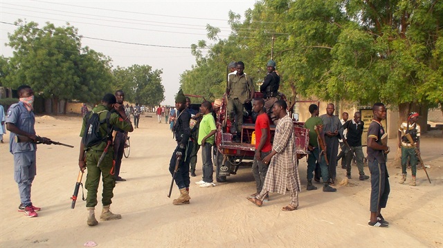 Local volunteers carrying weapons stand in the Jiddari Polo area in the northeastern city of Maiduguri, after an attack by Boko Haram militants, in Nigeria April 27, 2018.