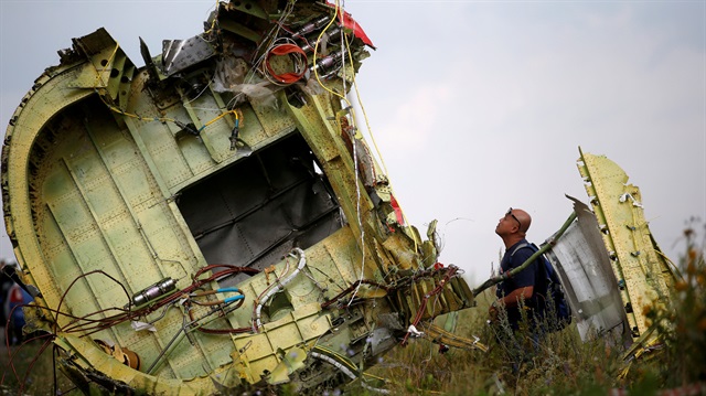 A Malaysian air crash investigator inspects the crash site of Malaysia Airlines Flight MH17, near the village of Hrabove (Grabovo) in Donetsk region, Ukraine, July 22, 2014. 
