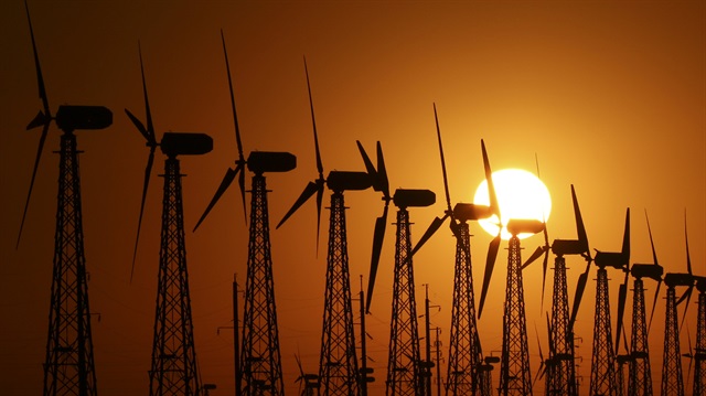 The sun sets behind power-generating turbines of a local wind farm in the settlement of Mirnyi, Crimea 

