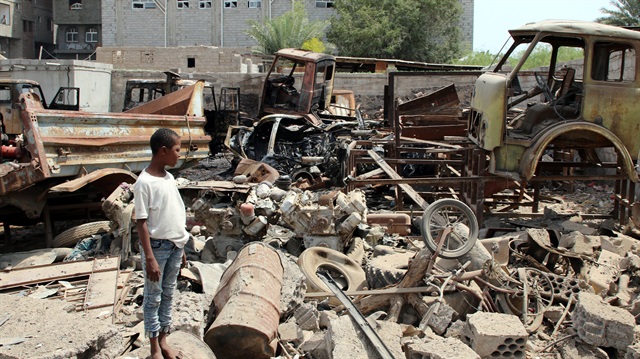 People inspect the damages after a car bomb ripped through a military kitchen in Aden