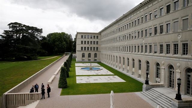 People talk outside the headquarters of the World Trade Organisation (WTO) in Geneva, Switzerland.