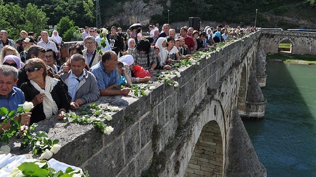 Relatives of Bosnian war victims throw roses into River Drina for each of 3,000 victims from massacres in early 1990s