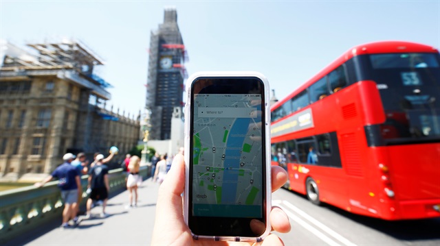 A photo illustration shows the Uber app and a bus in London, Britain, June 25, 2018. 