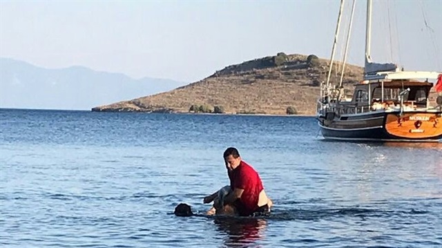 Bodrum Belediye Başkanı, denizde bir kadının hareketsiz durduğunu görünce suya girerek kadını sahile çıkardı.