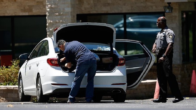 Cars and people go through a thorough search at a security post. 