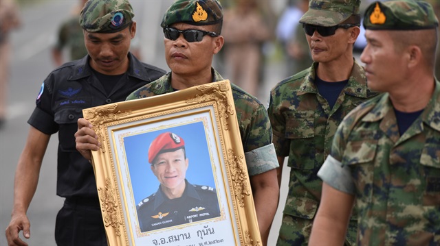 An honour guard hold up a picture of Samarn Kunan, 38, a former member of Thailand's elite navy SEAL unit who died working to save 12 boys and their soccer coach trapped inside a flooded cave, at an airport in Rayong province, Thailand.