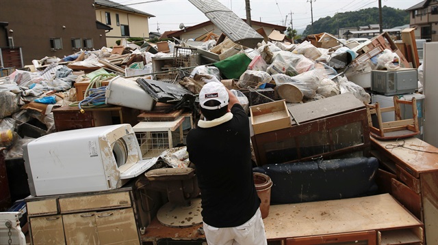 A local resident tries to clear debris at a flood affected area in Mabi town in Kurashiki, Okayama Prefecture, Japan.