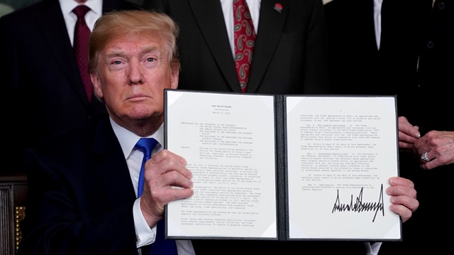 FILE PHOTO: U.S. President Donald Trump holds his signed memorandum on intellectual property tariffs on high-tech goods from China, at the White House in Washington, US.