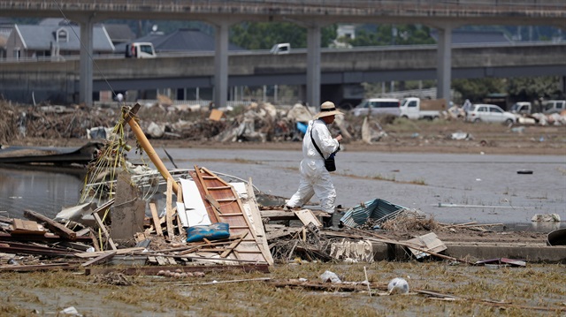 A local resident walks in a flooded area in Mabi town in Kurashiki, Okayama Prefecture, Japan, July 13, 2018.