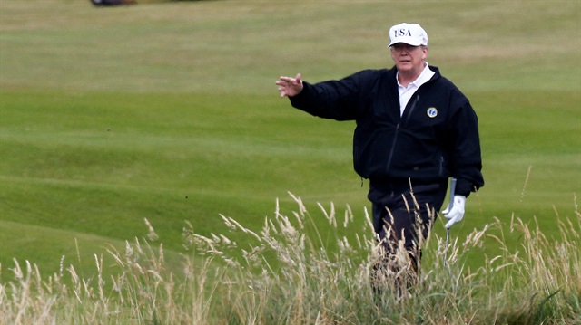 US President Donald Trump gestures as he walks on the course of his golf resort, in Turnberry, Scotland.