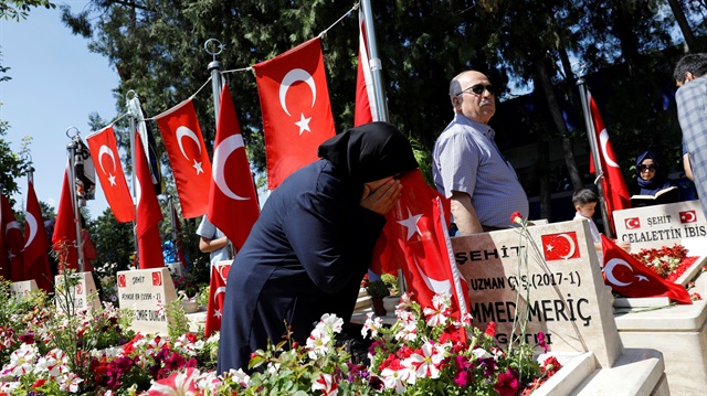 A woman mourns as she visits her son's grave who was killed during an attempted coup in 2016 as she attends a ceremony marking the second anniversary of the failed coup in Ankara, Turkey.