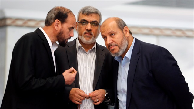 File Photo: Hamas leaders Izzat Reshiq (C) and Khalil al-Hayya (R) chat during a reconciliation deal signing ceremony in Cairo, Egypt.