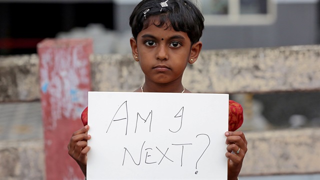 File photo: A girl holds a placard during a protest against the rape 