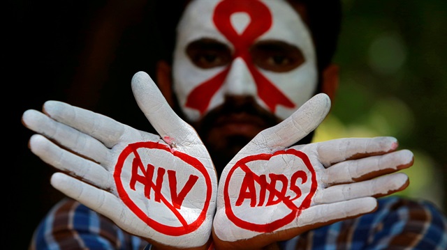 FILE PHOTO: A student displays his hands painted with messages as he poses during an HIV/AIDS awareness campaign to mark the International AIDS Candlelight Memorial, in Chandigarh, India.