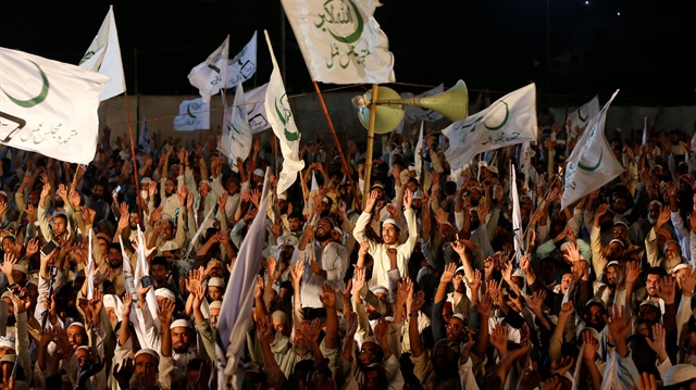Supporters of the Muttahida Majlis-e-Amal (MMA), a coalition between religious-political parties, chant slogans and wave flags, during a campaign rally, ahead of general elections in Karachi, Pakistan July 15, 2018. 