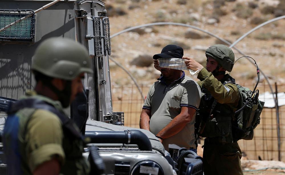 İsrail askerleri, halihazırda Filistinlilere insanlık dışı muamelelerde bulunurken, yeni tanınan yasa ile bu uygulamaların artması bekleniyor... (Batı Şeria'da gözaltına alınan bir Filistinli...)