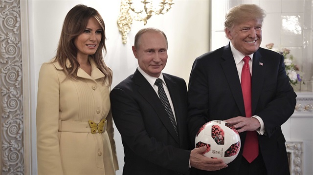 Russia's President Vladimir Putin (C), U.S. President Donald Trump (R) and First lady Melania Trump pose for a picture with a football during a meeting in Helsinki, Finland July 16, 2018.
