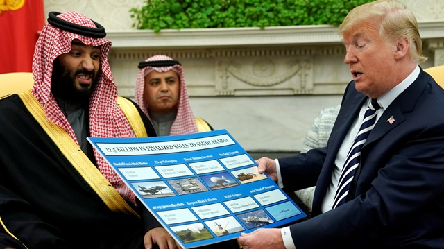 U.S. President Donald Trump holds a chart of military hardware sales as he welcomes Saudi Arabia's Crown Prince Mohammed bin Salman in the Oval Office at the White House in Washington, U.S. March 20, 2018.