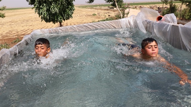 Çocukları sıcaktan bunalan baba römorku havuza çevirdi.