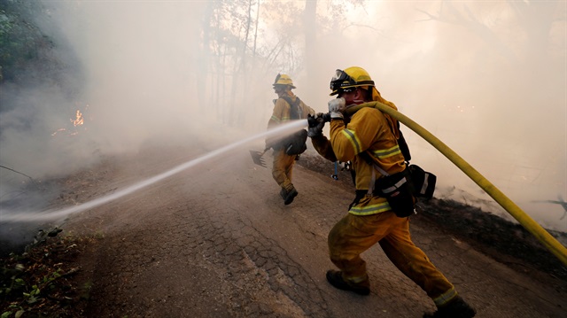 A firefighter knocks down hotspots to slow the spread of the River Fire (Mendocino Complex) in Lakeport, California, U.S.