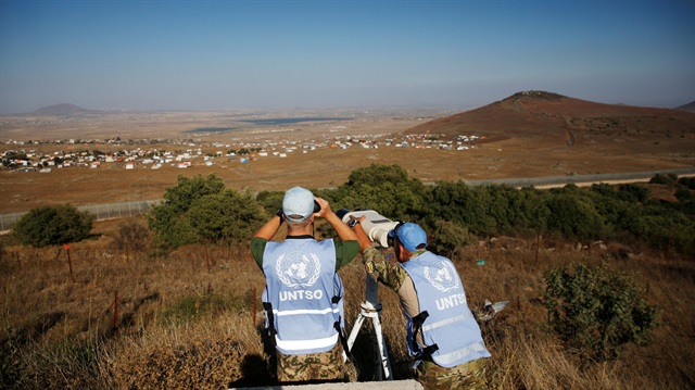 File photo: Peacekeeping troops from the unarmed United Nations Truce Supervision Organisation (UNTSO) look over the border line between Israel and Syria at a refugee tents erected at its Syrian side and seen from the Israeli-occupied Golan Heights