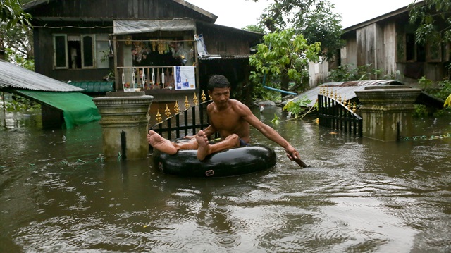 A man travels through a flooded street in Bago, Myanmar