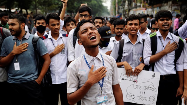 Students sing the national anthem as they take part in a protest over recent traffic accidents that killed a boy and a girl, in Dhaka, Bangladesh.
