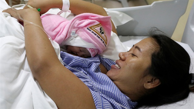 Pan Ei Mon, the wife of detained Reuters journalist Wa Lone, embraces her new born baby girl Thet Htar Angel in her hospital room in Yangon, Myanmar 