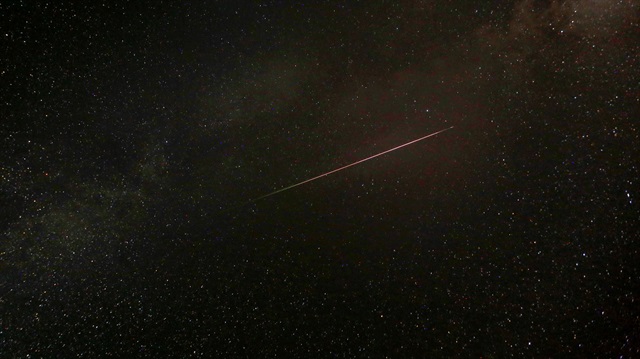 A meteor streaks over the skies over the Milky Way 