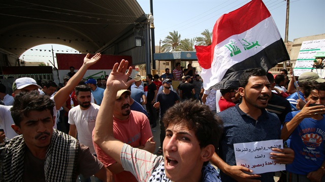 File photo: Iraqi men shout slogans during a protest in front of Basra provincial council building