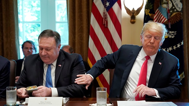 U.S. President Donald Trump pats U.S. Secretary of State Mike Pompeo on the arm after Pompeo read a prayer at the start of a cabinet meeting at the White House in Washington, U.S.