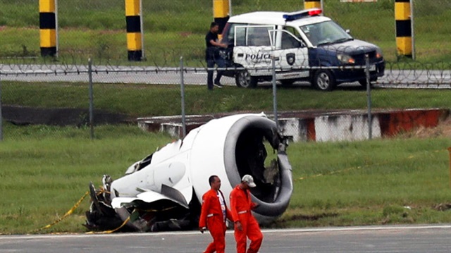 Rescue workers walk past the detached left engine of a Xiamen Air Boeing 737-800 after it skidded off at the runway of Ninoy Aquino International airport in Paranaque, Metro Manila, in the Philippines