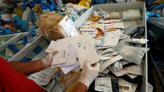 A Palestinian worker displays items sent by mail eight years ago