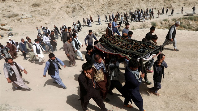 People carry the body of one of the victims of yesterday's suicide attack 