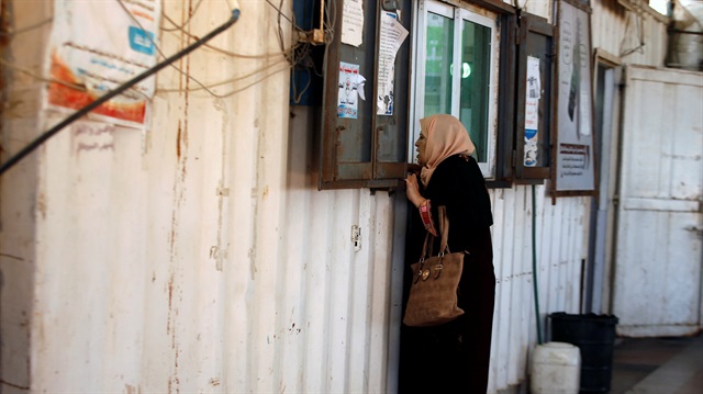 A Palestinian woman presents her documents for the staff at Erez crossing with Israel
