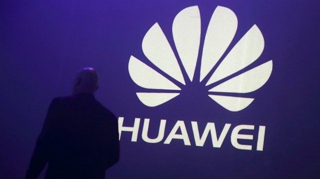File photo:  A man walks past a logo during the presentation the Huawei's new smartphone, the Ascend P7, launched by China's Huawei Technologies in Paris