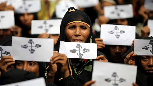 Rohingya refugee women hold placards as they take part in a protest 