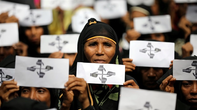Rohingya refugee women hold placards as they take part in a protest at the Kutupalong refugee camp to mark the one-year anniversary of their exodus in Cox's Bazar, Bangladesh