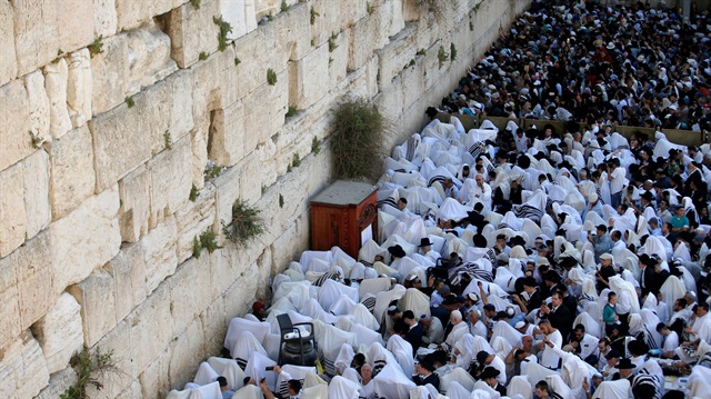 Jewish worshippers wrapped in prayer shawls participate in the priestly blessing prayer on the holiday of Passover, at the Western Wall in Jerusalem's Old City