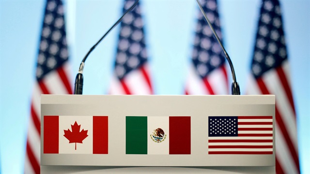 The flags of Canada, Mexico and the U.S. are seen on a lectern before a joint news conference on the closing of the seventh round of NAFTA talks in Mexico City, Mexico, March 5, 2018.
