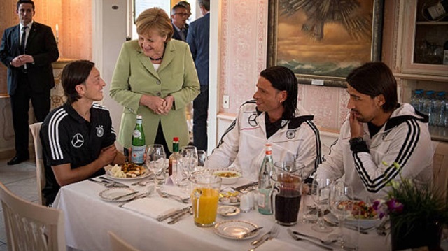 German Chancellor Angela Merkel talks to German National Team players Mesut Özil (L), Tim Wiese (C) and Sami Khedira during a shared dinner at the Euro 2012 Team Hotel on June 6, 2012 in Sopot, Poland.