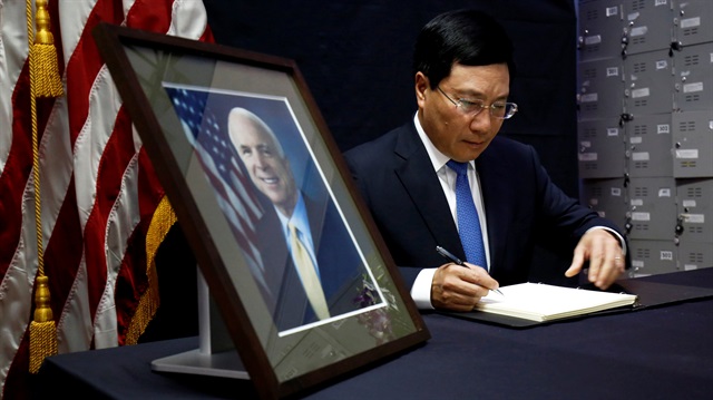 Vietnam's Deputy Prime Minister and Foreign Minister Pham Binh Minh writes in a condolence book near a portrait of U.S. Senator John McCain (R-AZ) about his death at the U.S. embassy in Hanoi, Vietnam August 27, 2018.