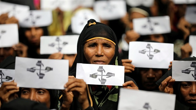 Rohingya refugee women hold placards as they take part in a protest at the Kutupalong refugee camp to mark the one-year anniversary of their exodus in Cox's Bazar, Bangladesh