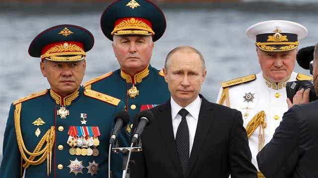 Russian Defence Minister Sergei Shoigu, Commander of Western military district Andrei Kartapolov, President Vladimir Putin and Commander-in-Chief of the Russian Navy Vladimir Korolev arrive to attend the the Navy Day parade in St. Petersburg, Russia