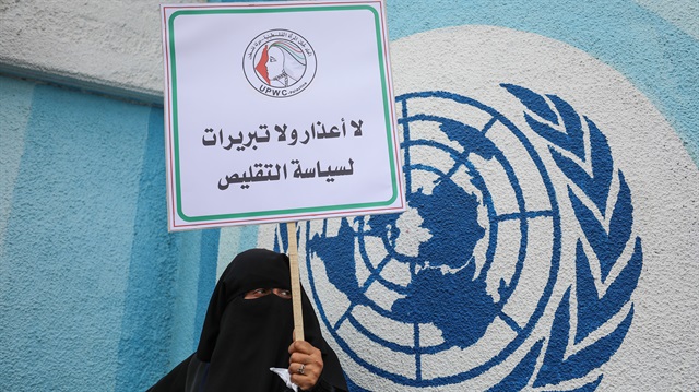 Filistinli bir kadın, UNRWA önünde protesto gösterisi düzenliyor. 