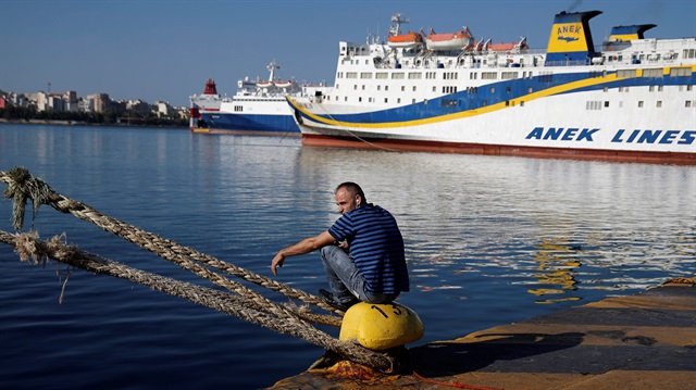 A man rests next to moored passenger ferries during a second consecutive 24-hour strike of Greece's seamen's federation PNO against austerity policies affecting their sector, at the port of Piraeus, Greece, September 4, 2018