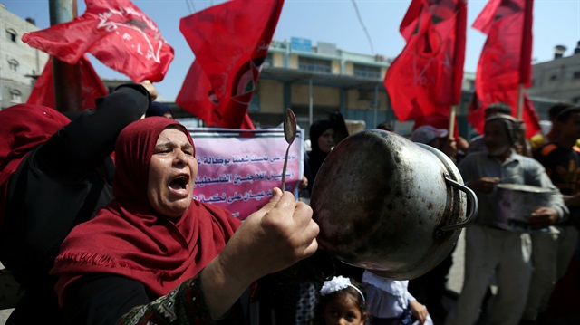 A Palestinian woman holds a cooking pot during a protest against a U.S. decision to cut aid to UNRWA