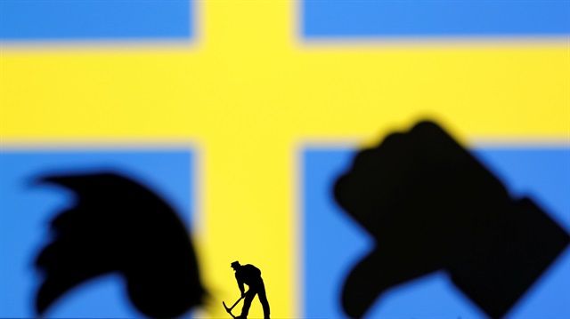 A small toy figure is seen in front of 3-D printed Twitter and Facebook logos and displayed a Sweden flag in this illustration picture