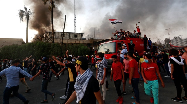 Iraqi protesters stand on a fire truck during an anti-government protest 