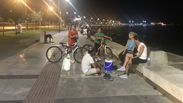 İzmir'de kenti saran kokuya tepki gösteren vatandaşlar, çözümü ev yerine sahilde oturmakta arıyor. 